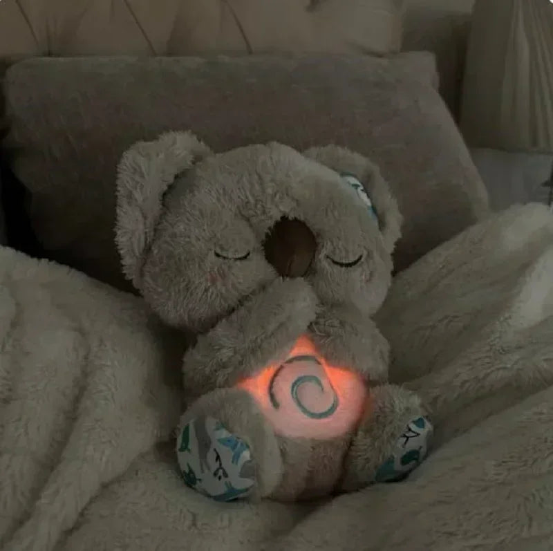 Baby Breathing Otter Plush with Light & Sound Plush teddy bear with a glowing orange light on a soft surface