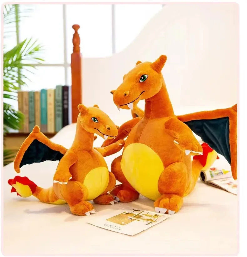 Pokemon Charizard Plush Toy – Cute Kawaii Stuffed Animal Two orange and yellow Charizard plush toys posed on a white bed in a bedroom setting, with a bookshelf and window visible in the background.