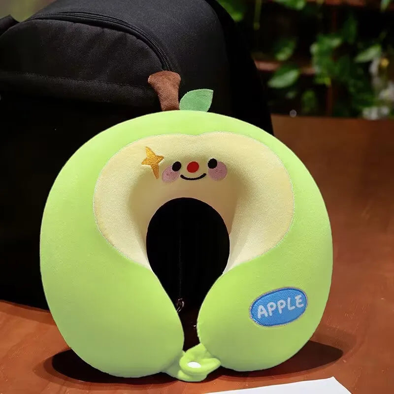 Cute Capybara U-Shaped Neck Pillow – Plush Travel Pillow Green apple-shaped neck pillow with a smiling face on a wooden surface.