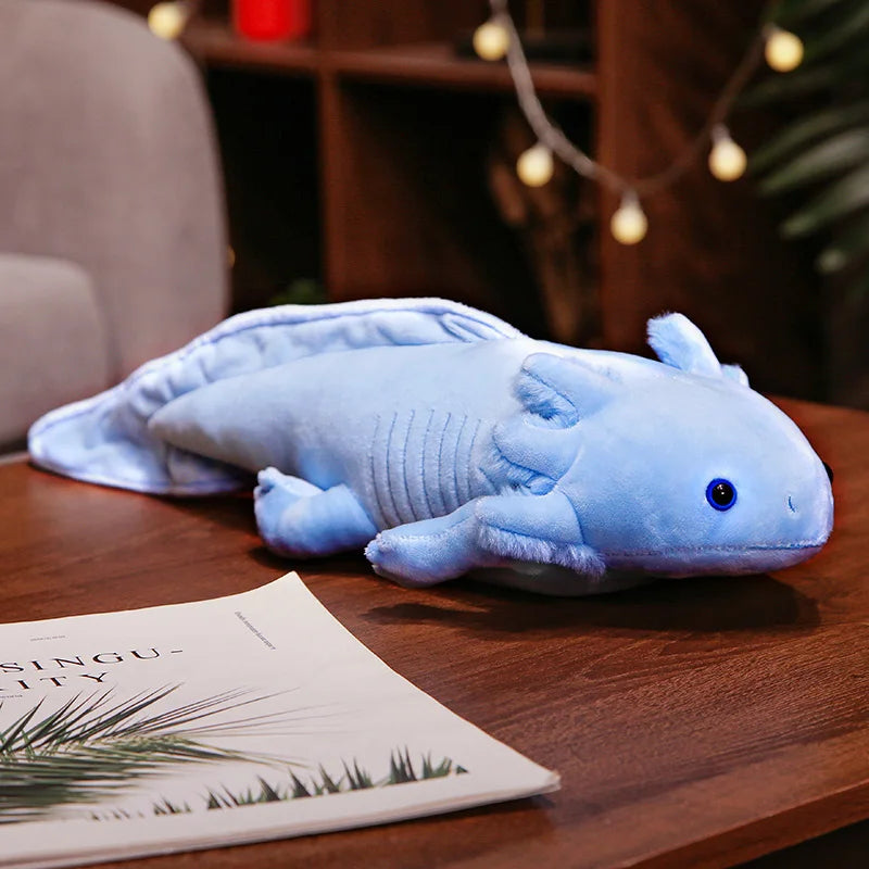 Cute Axolotl Plush Toy – Squishmallow Salamander Stuffed Animal Blue axolotl plush toy on a wooden table with a magazine underneath