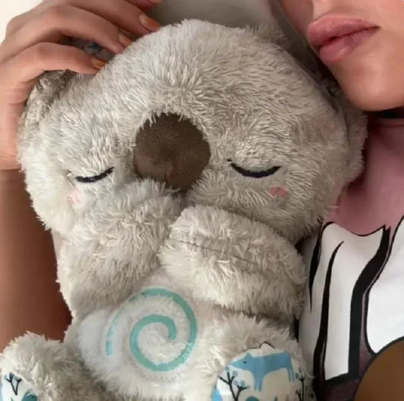 Baby Breathing Otter Plush with Light & Sound Person holding a plush toy resembling a cat with closed eyes