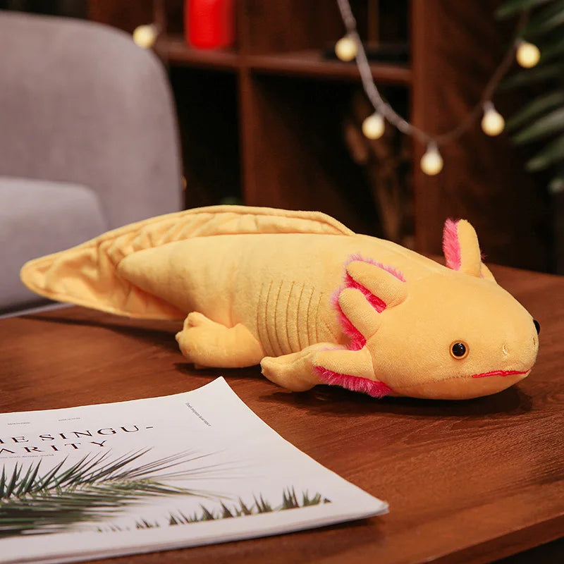 Cute Axolotl Plush Toy – Squishmallow Salamander Stuffed Animal Plush axolotl toy on a wooden surface with a magazine underneath