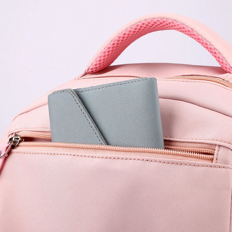 Capybara Bubble Tea Backpack – School Bag for Teens A light pink backpack with a top handle and a zippered pocket, shown with a gray wallet or card holder partially pulled out. The photo is a close-up studio shot on a pale pink background.