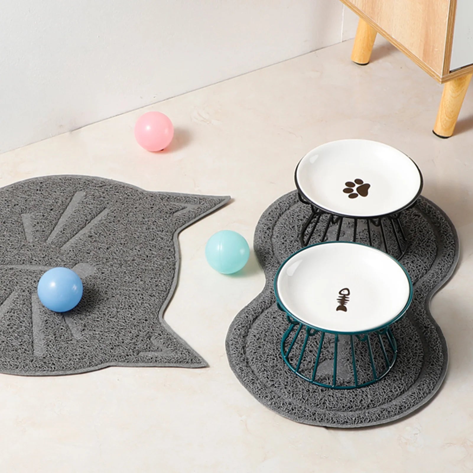 Ceramic Elevated Pet Bowl with Stand Food & Water Pet bowls on gray mats with colorful balls on a light wooden floor.