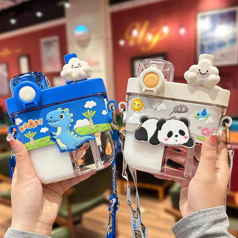 Capybara Kids Water Bottle – Cartoon Straw Cup Two cartoon water bottles held in hands, one blue with a dinosaur and the other white with a panda, both with cute cloud and sun decorations on the lids, set against a blurred indoor background.