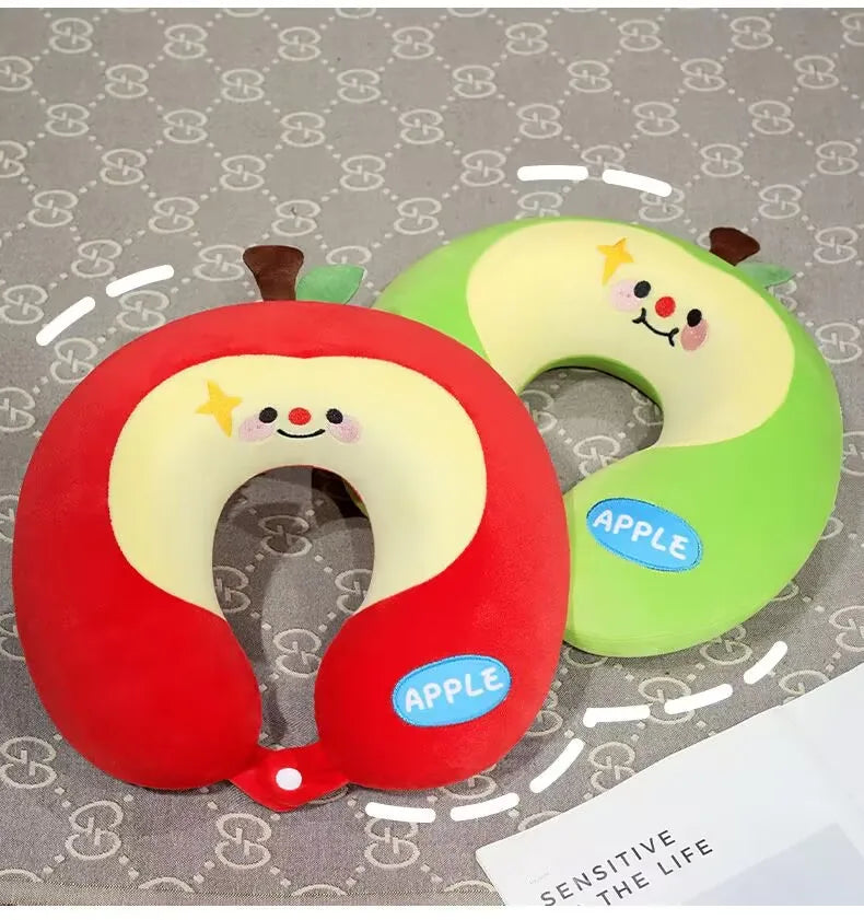 Cute Capybara U-Shaped Neck Pillow – Plush Travel Pillow Two plush apple-shaped neck pillows, one red and one green, with cartoon faces and the word APPLE on a patterned gray background.