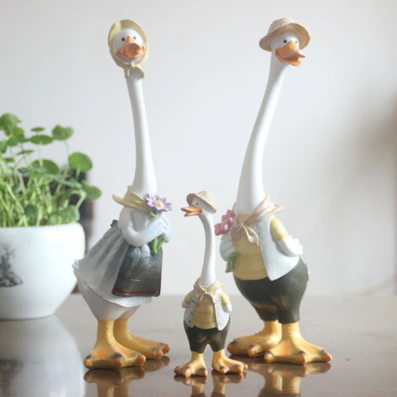 Resin Duck Family Garden Statue – Animal Outdoor Decor Sculpture Decorative goose figurines with accessories on a reflective surface.
