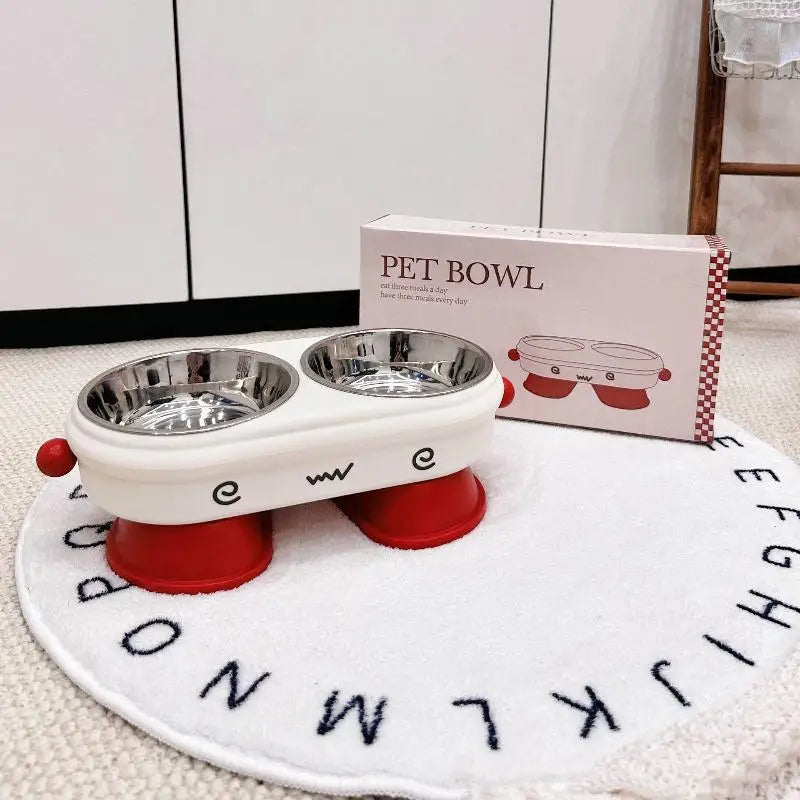 Elevated Pet Bowl Stainless Steel Anti-Slip Feeding Dish Pet bowl set with red and white design on a mat with letters, next to a box labeled 'Pet Bowl'.