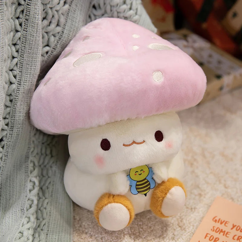 Creative Mushroom Plush Pillow – Cute Stuffed Plant Cushion for Home Décor Cute plush toy with a pink mushroom cap and bee design on a textured surface.