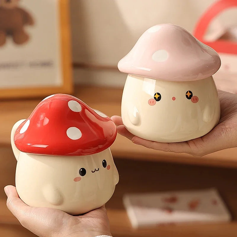 Cute Mushroom Coffee Mug with Lid – 400ML Ceramic Cup Two cute mushroom-shaped ceramic containers held in hands with a blurred background.