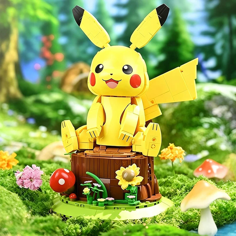 Pokemon Pikachu Building Blocks – DIY Model Brick Toy A yellow Pikachu building-block figure sits on a small tree stump base in a colorful forest scene. The figure has black-tipped ears, red cheeks, and large wings, with flowers, mushrooms, and green moss around it.