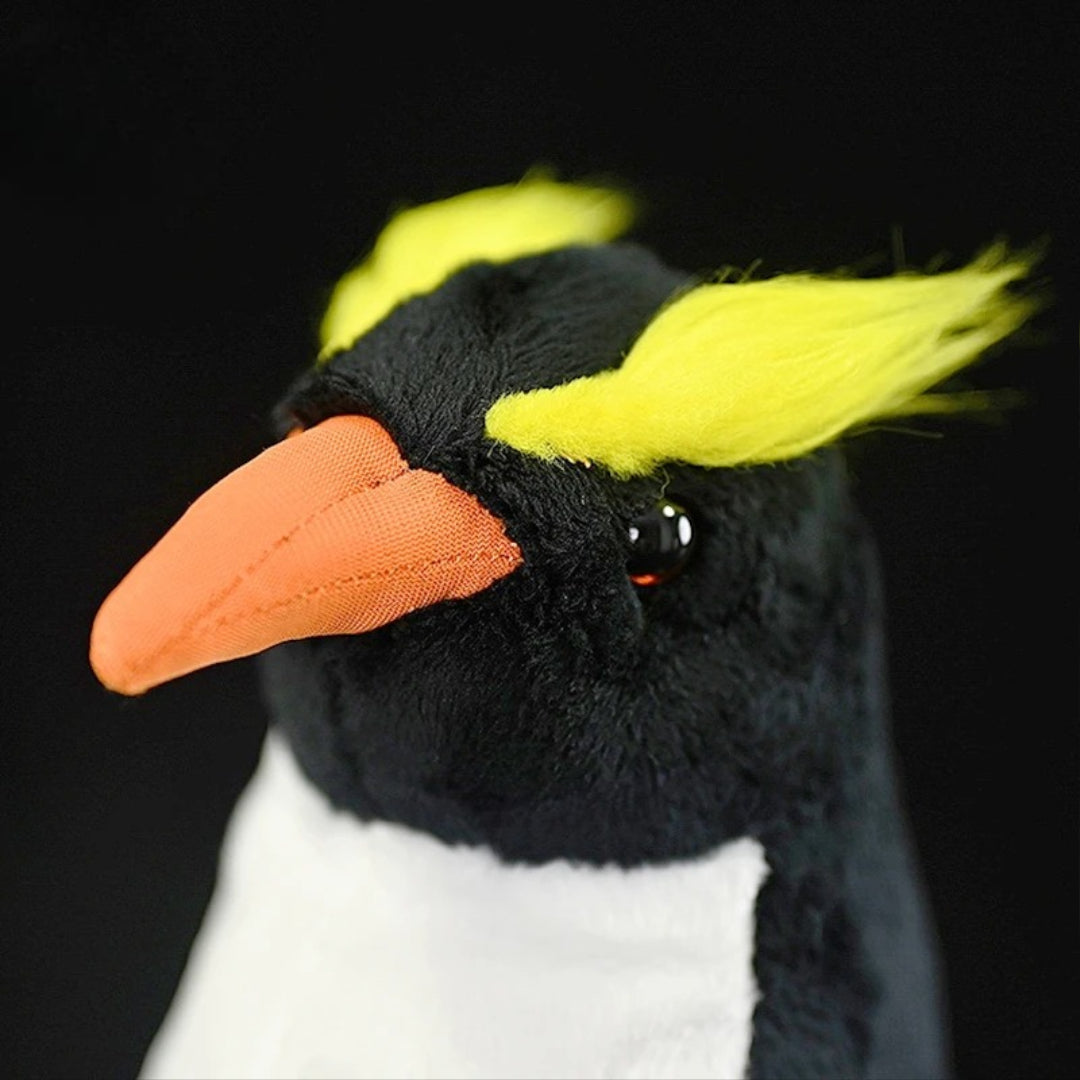 Realistic Penguin Plush Toy - Adélie Penguin Stuffed Animal Close-up of a plush penguin toy with a black head, white chest, and orange beak on a black background.