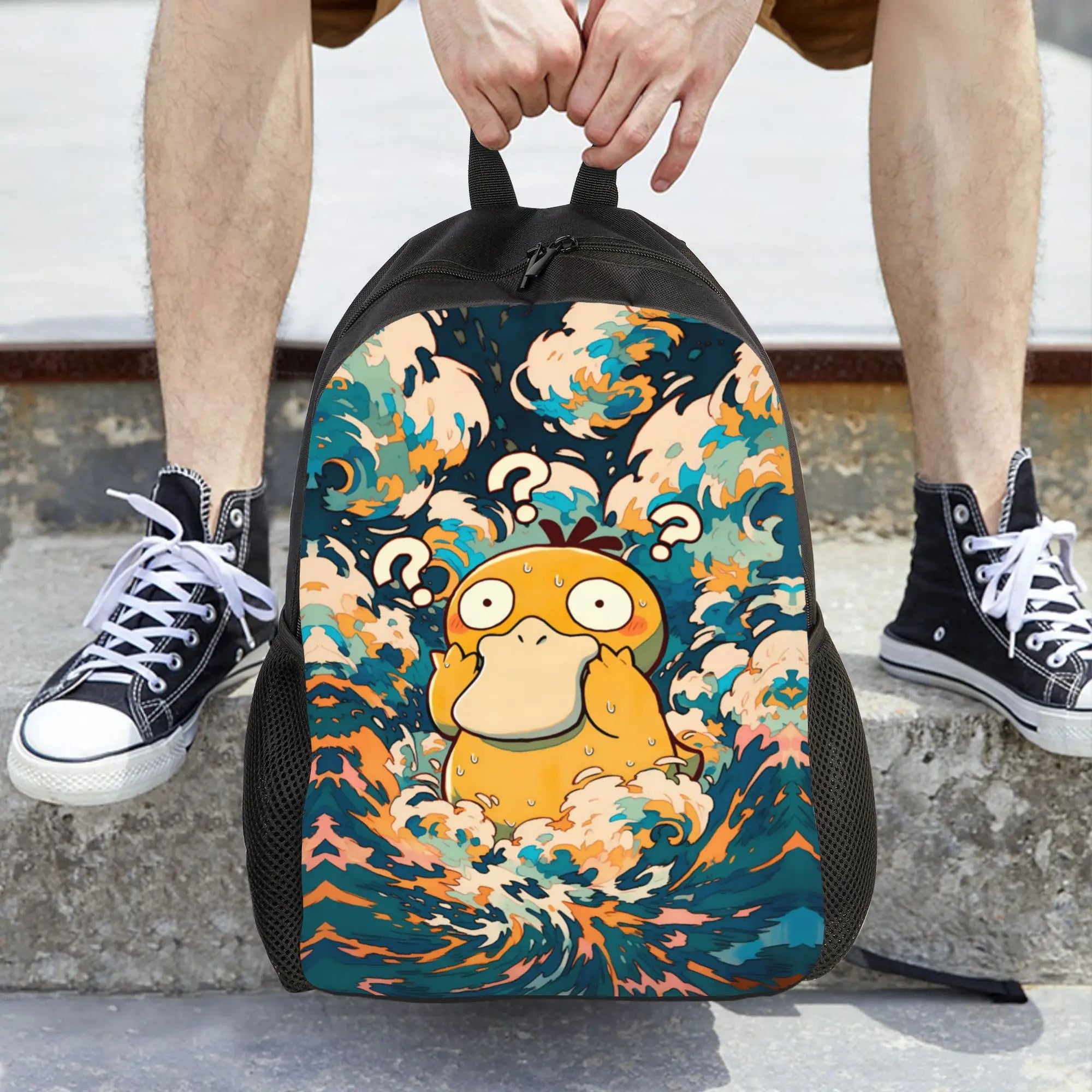 Pokemon Psyduck Laptop Backpack – School Bag A person sitting on concrete steps holds the top of a backpack featuring a colorful wave illustration and a yellow cartoon character. The person is wearing black high-top sneakers.