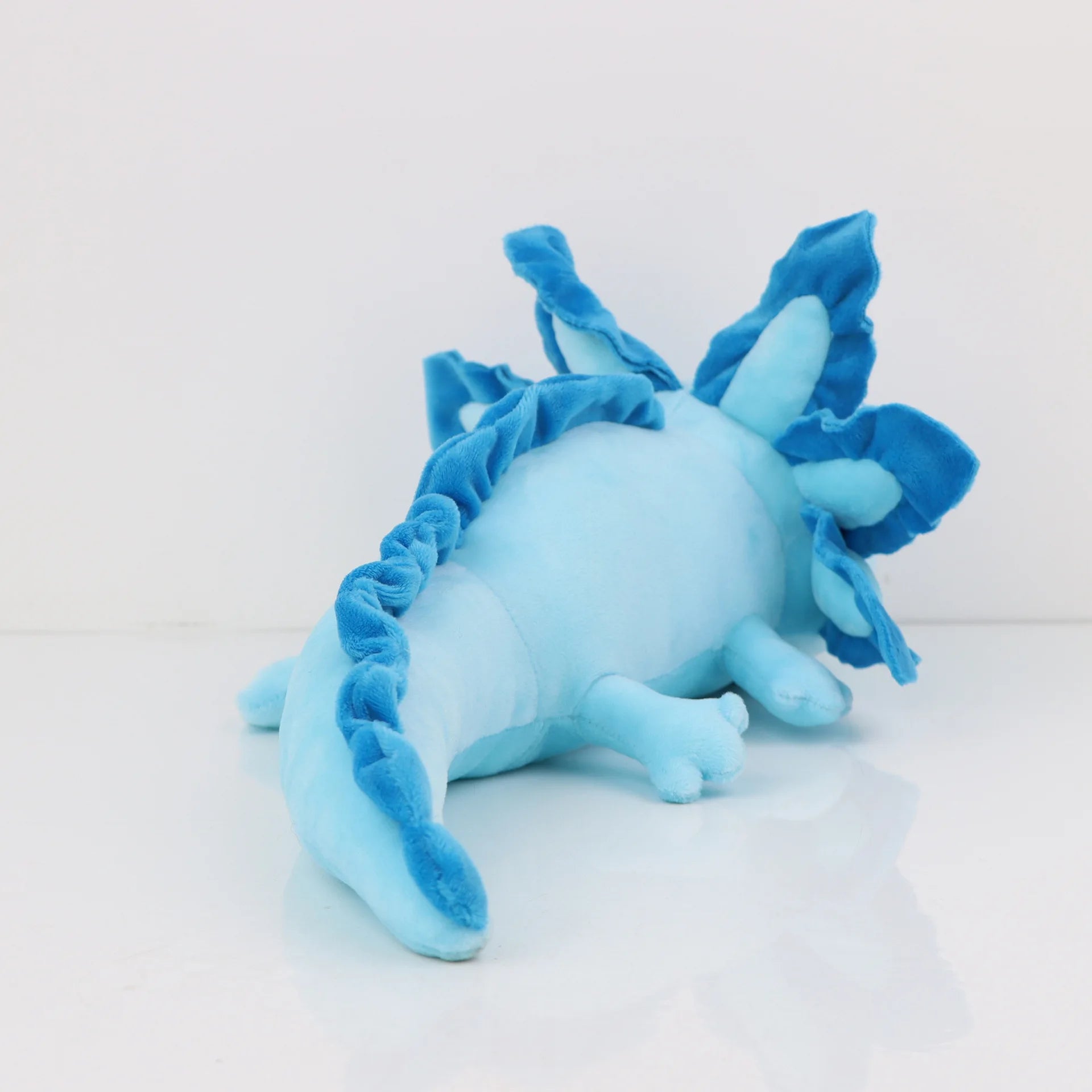 Axolotl Squishmallow Plush Toy – Soft Stuffed Animal Blue plush toy resembling a stegosaurus on a white background