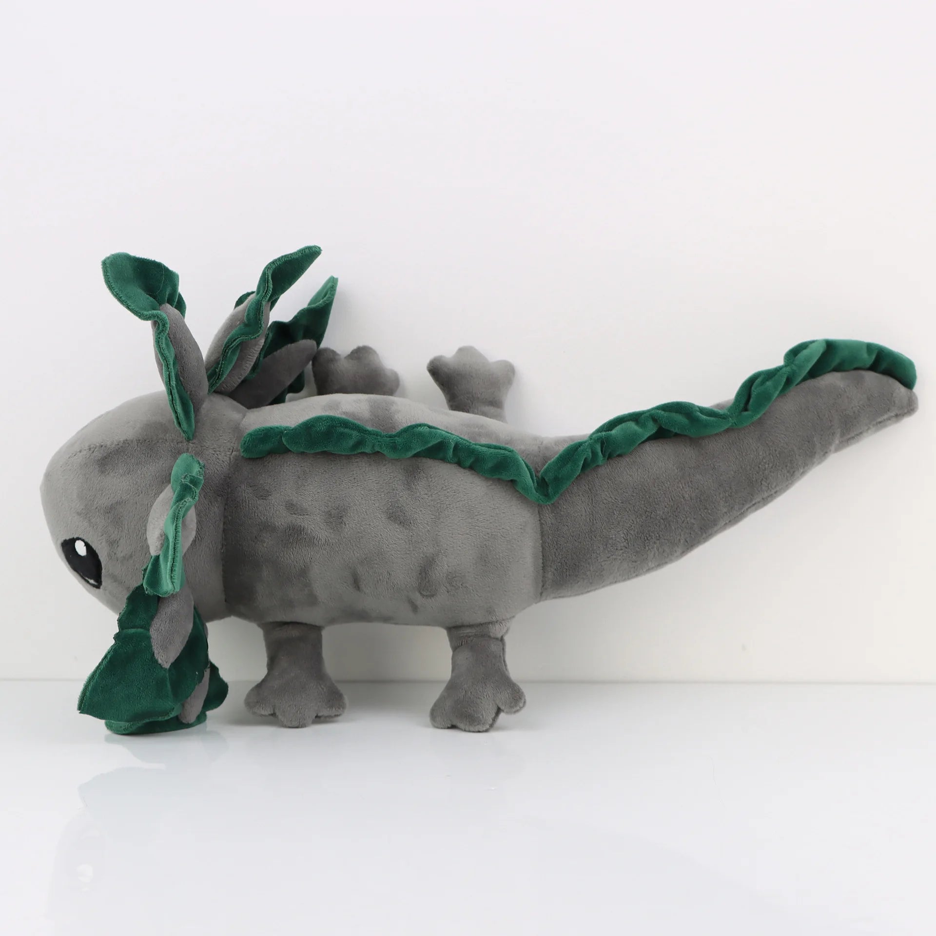 Axolotl Squishmallow Plush Toy – Soft Stuffed Animal Gray plush axolotl toy with green leaf-like appendages on a white background