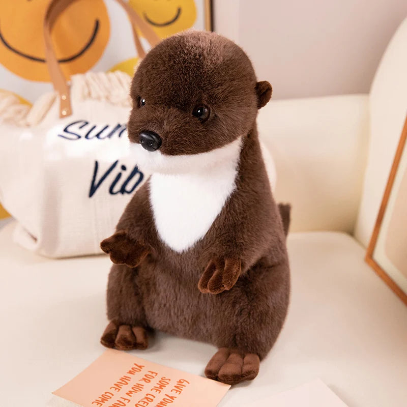 Realistic Otter Plush Toy Plush toy otter on a white surface with a decorative pillow in the background