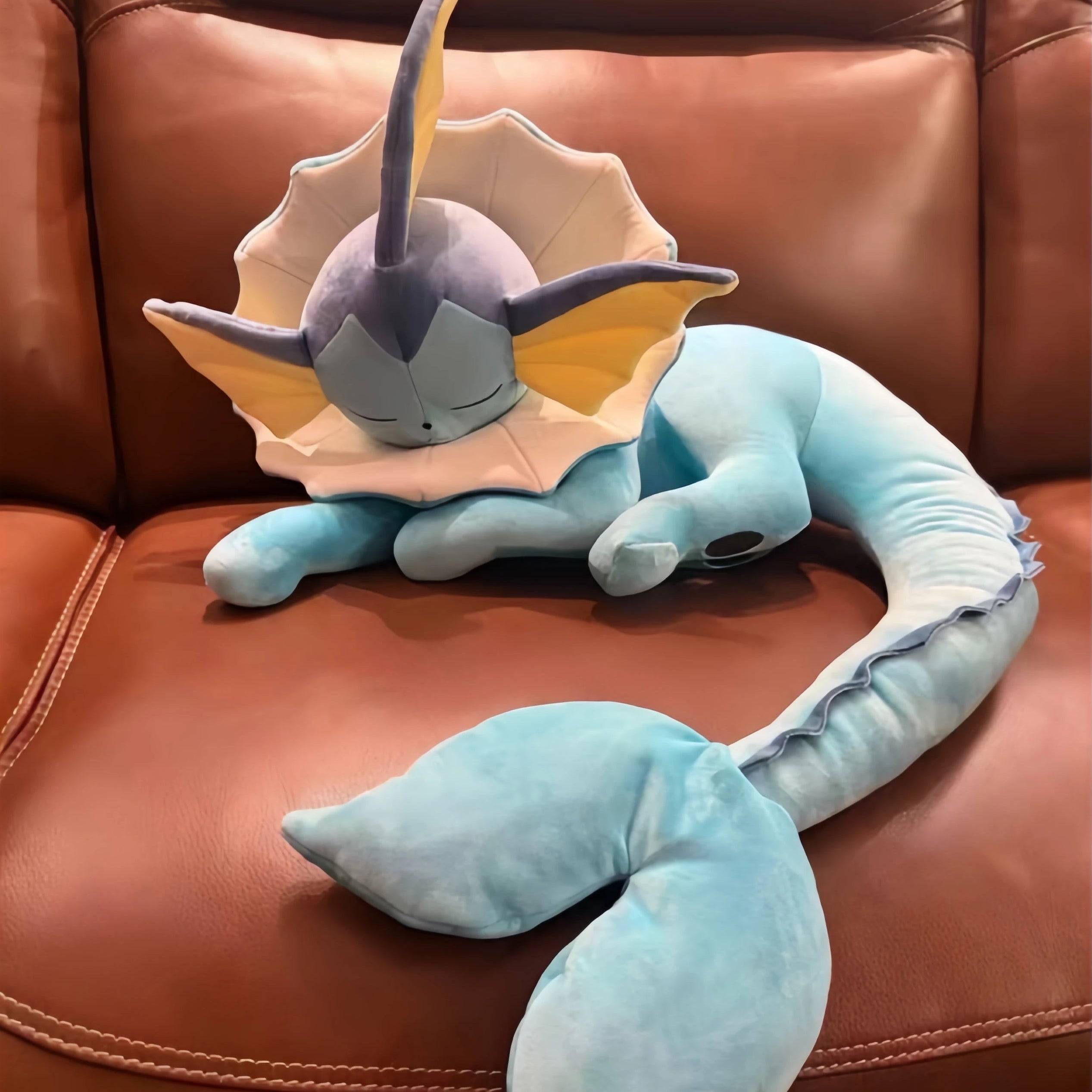 Pokemon Eevee Plush Toy Vaporeon Stuffed Animal Plush toy resembling a dragon-like creature on a brown leather couch