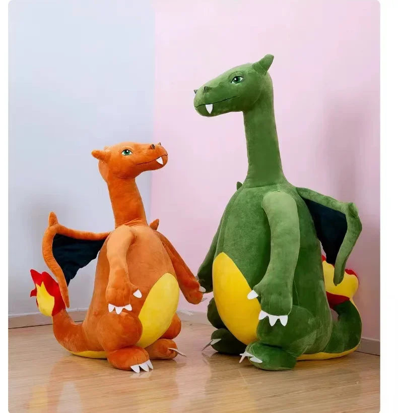 Pokemon Charizard Plush Toy – Cute Kawaii Stuffed Animal Two plush dragon toys, resembling Charizard and a green dragon variant, sitting on a wooden floor against a split white and pink wall.