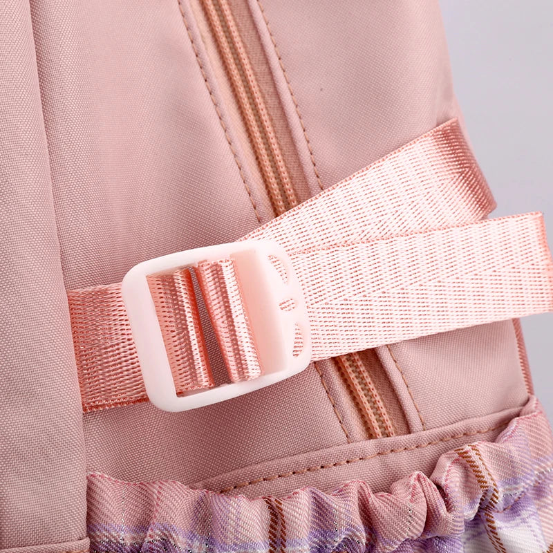 Capybara Bubble Tea Backpack – School Bag for Teens Close-up of a pink fabric backpack or bag with a wide adjustable elastic strap and white plastic buckle, plus a ruffled trim at the bottom.