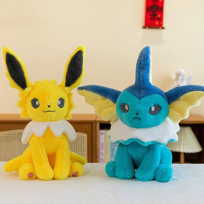 Pokemon Eevee Plush Toy – Vaporeon, Flareon & Jolteon Soft Stuffed Animal Two plush toy Pokémon, Eevee in yellow and Vaporeo in blue, sitting side by side on a white surface in an indoor setting.