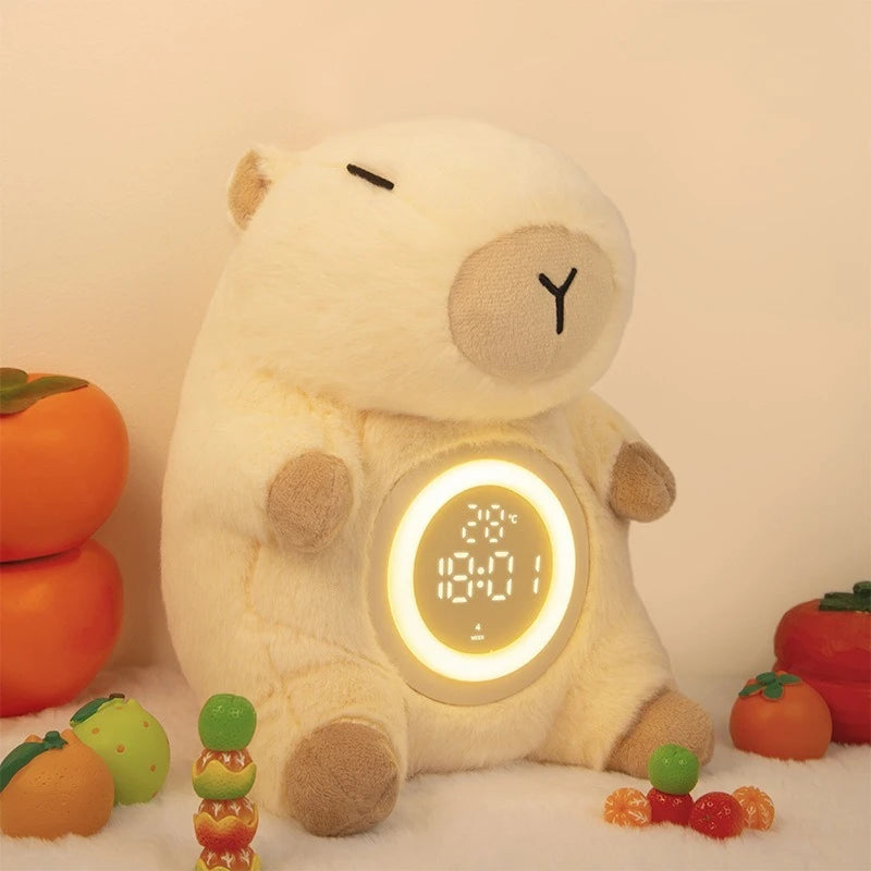 Capybara Plush Alarm Clock & Night Light – Adjustable Brightness Plush bear clock with digital display surrounded by small fruits and candies on a light background