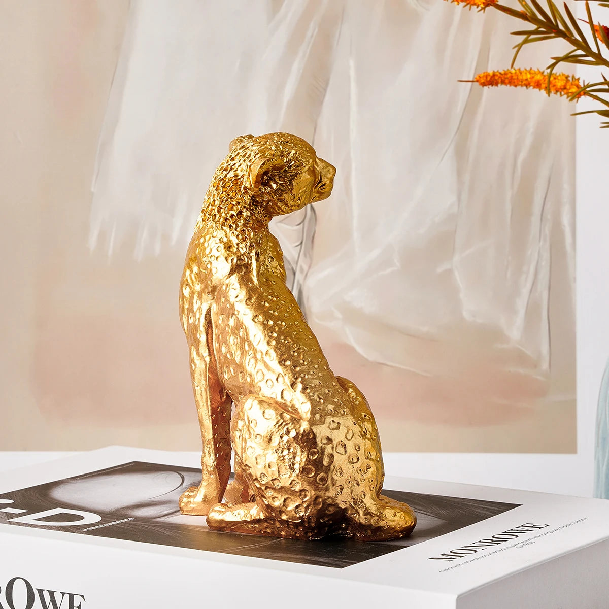 Golden Leopard Figurine – Resin Animal Desktop Decor Sculpture Gold panther statue on a white surface with a blurred background