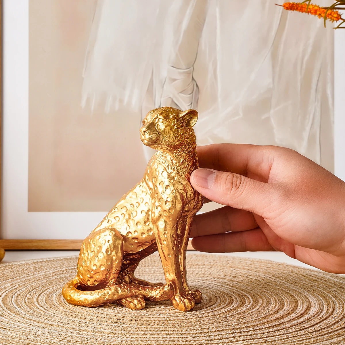 Golden Leopard Figurine – Resin Animal Desktop Decor Sculpture Gold panther figurine held by a hand on a textured surface with a neutral background