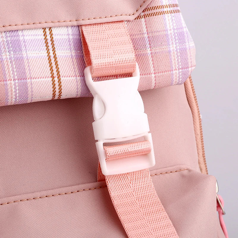 Capybara Bubble Tea Backpack – School Bag for Teens Close-up of a pink backpack strap with a white plastic buckle and a pink, purple, and white plaid fabric accent.