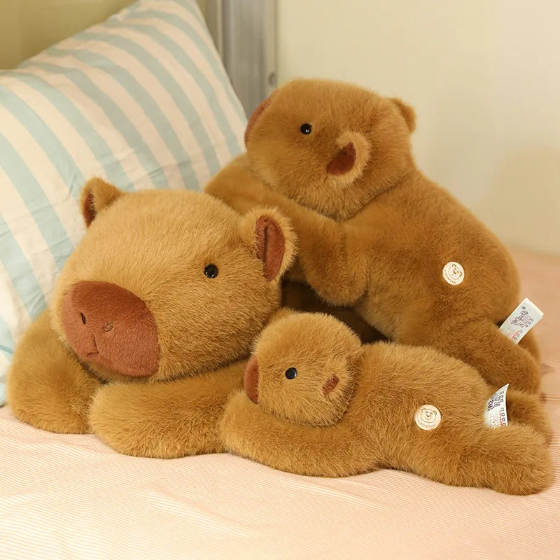 Weighted Capybara Plush Pillow – Soft Stuffed Animal Three brown teddy bears of different sizes sitting together on a bed.