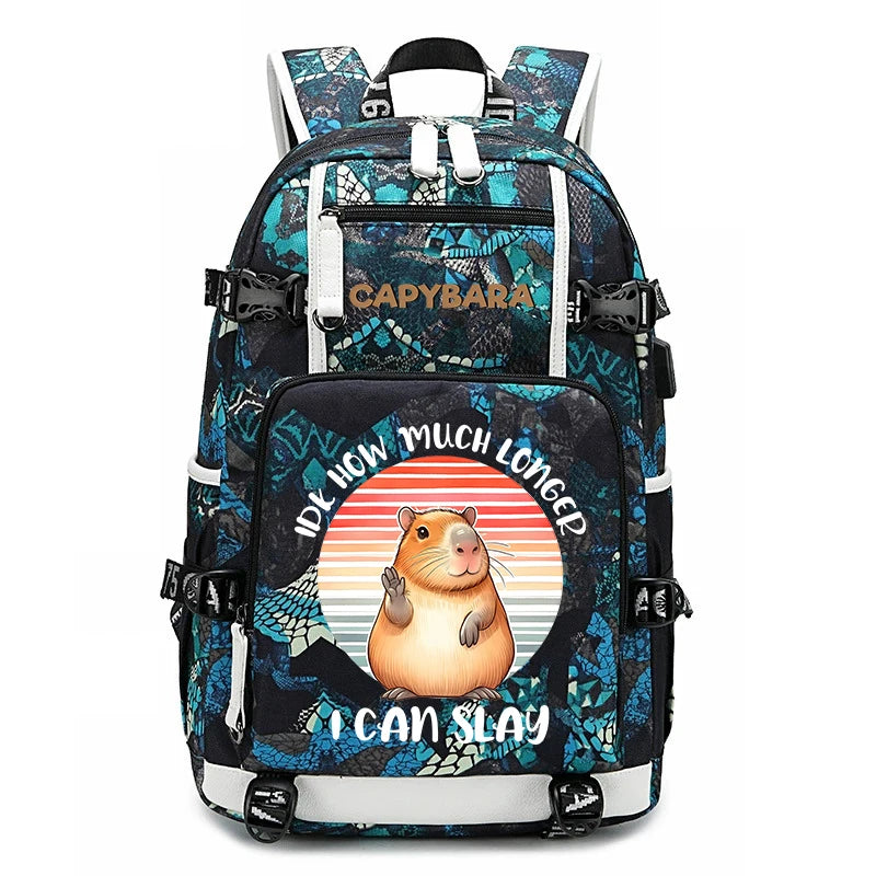 Capybara Backpack – Large Capacity Lightweight School Bag A black and teal patterned backpack with a cartoon hamster graphic and the text 'IDK HOW MUCH LONGER I CAN SLAY' on the front pocket. The brand name 'CAPYBARA' is printed on the upper front pocket.