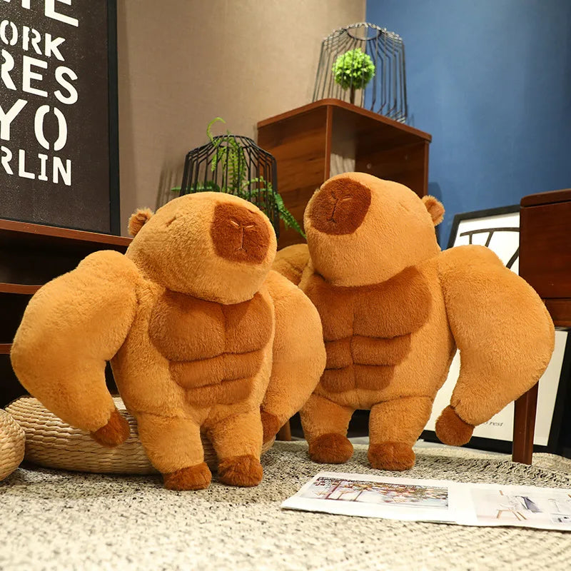 Muscle Capybara Plush Pillow – Funny Brown Stuffed Animal Cushion Two muscular plush bear toys with exaggerated biceps, posed indoors on a carpeted floor in a styled room setting with shelves, plants, and framed wall art.