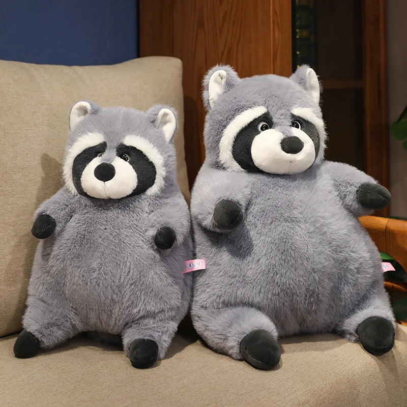 Squishmallow Grey Raccoon Plush Toy Stuffed Animal Two plush raccoons sitting on a couch.
