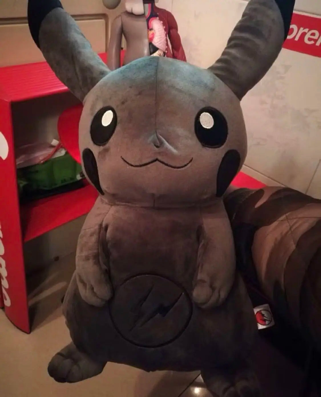 Dark Pikachu Plush Pillow Black Kawaii Doll Plush toy with large ears and a lightning bolt symbol on a red shelf.