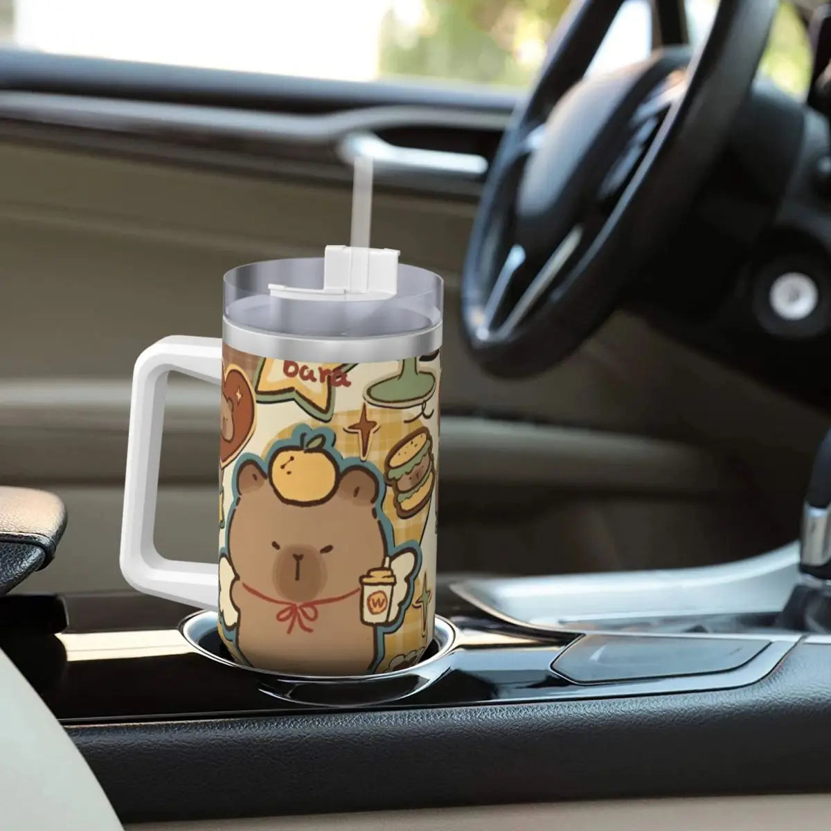 Capybara Insulated Tumbler – Stainless Steel Hot & Cold Drink Cup A handled stainless steel travel tumbler with a cartoon capybara and coffee-themed illustration, shown in a car cup holder.