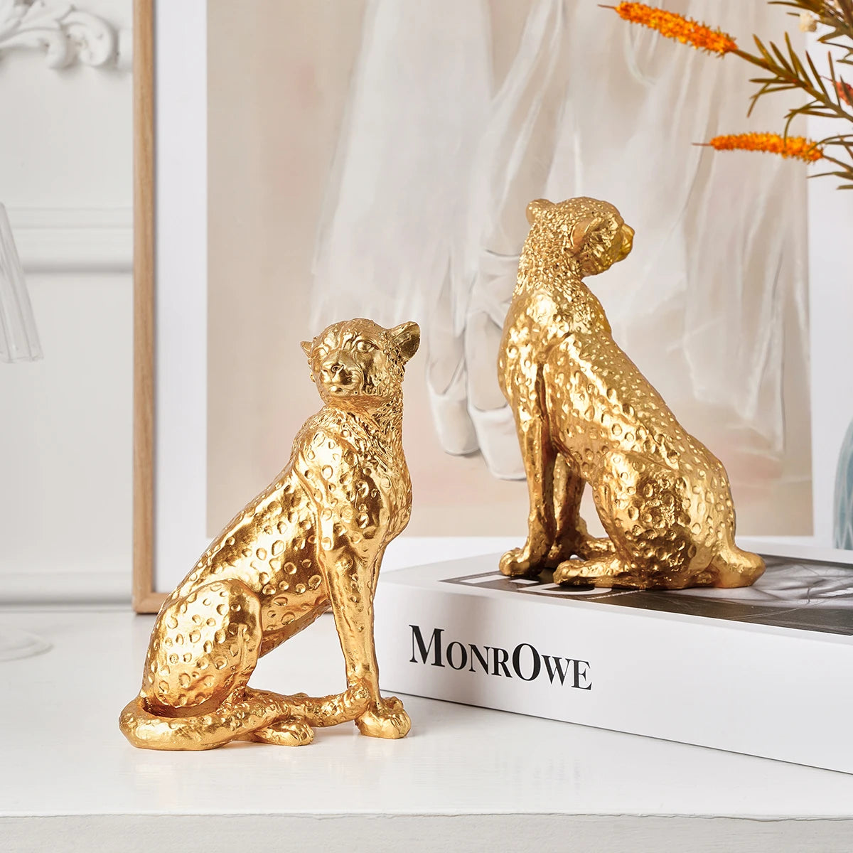 Golden Leopard Figurine – Resin Animal Desktop Decor Sculpture Two gold leopard figurines on a book