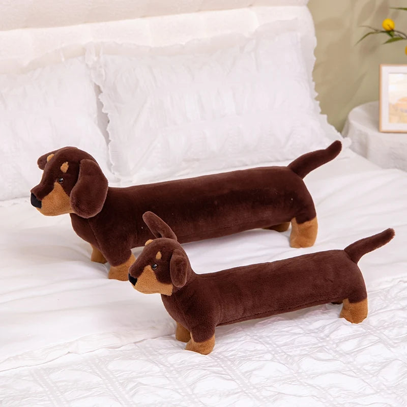 Realistic Dachshund Plush Dog Stuffed Animal Two brown dachshund plush toys on a white bed.