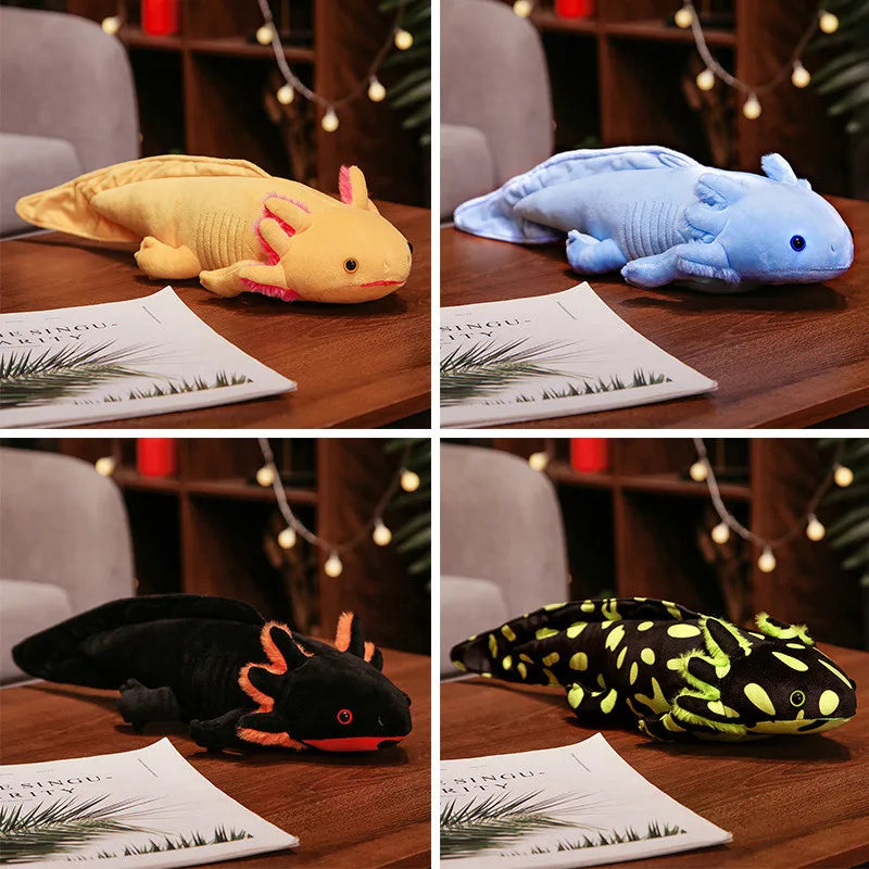 Cute Axolotl Plush Toy – Squishmallow Salamander Stuffed Animal Four plush axolotl toys arranged in a 2x2 grid on wooden tables, each shown in a different colorway: yellow with pink gills, light blue, black with orange accents, and black with neon yellow spots. Papers are placed in front of each toy, and a blurred indoor background with string lights and chairs is visible.