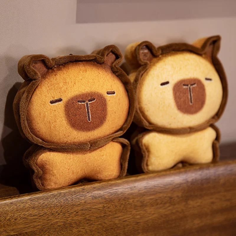 Capybara Bread Pillow – Cute Toast Plush Cushion Two plush toys resembling bears with closed eyes on a wooden surface.