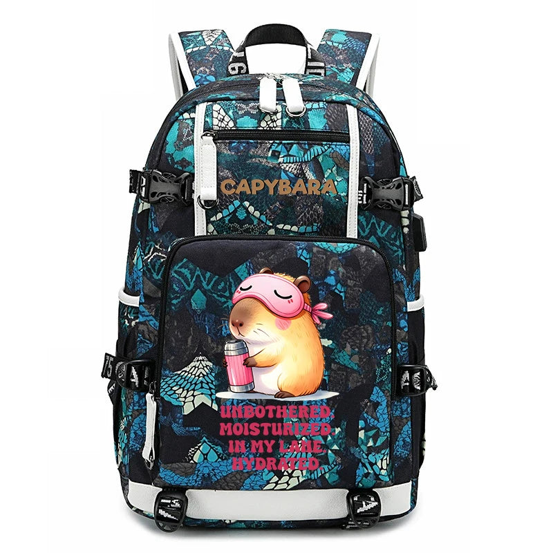 Capybara Backpack – Large Capacity Lightweight School Bag A CAPYBARA brand backpack featuring a black and teal blue patterned design with a cartoon guinea pig graphic on the front pocket, holding a pink drink with the text 'UNBOTHERED MOISTURIZERS IN MY TAIL'.