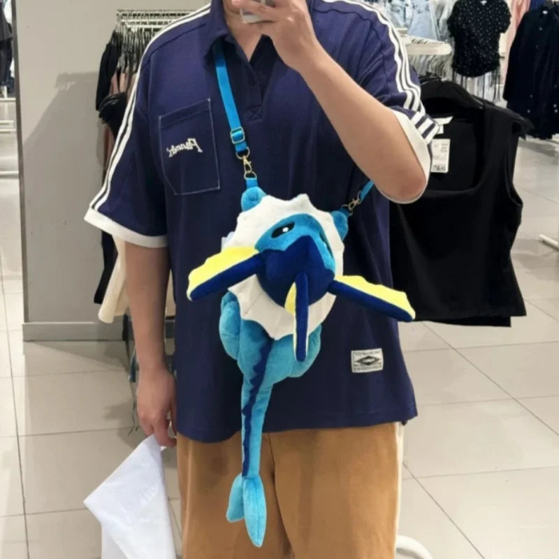 Pokemon Eevee Evolution Plush Crossbody Bag A person taking a mirror selfie in a clothing store, wearing a blue and white plush shark crossbody bag with yellow accents over a navy blue Adidas-style shirt.