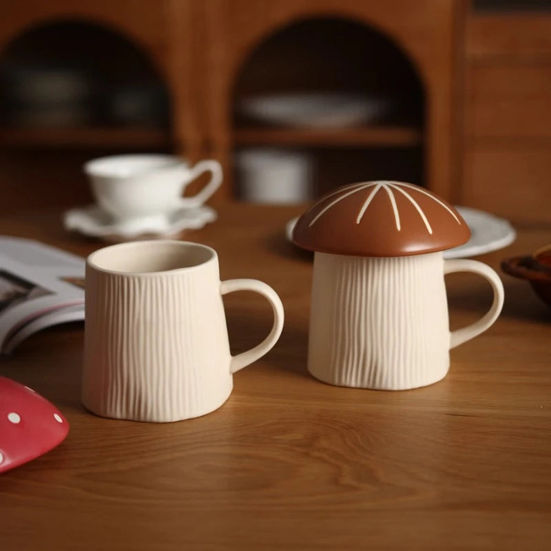 Mushroom Coffee Mug with Lid – Cute Drinking Cup Two ceramic mugs with a mushroom design on a wooden surface.