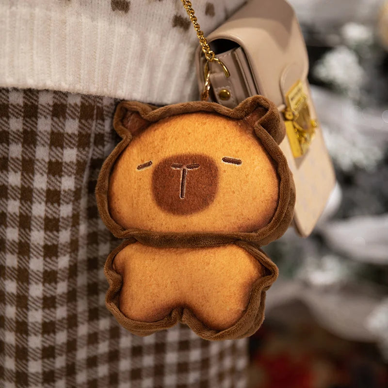 Capybara Bread Pillow – Cute Toast Plush Cushion Brown bear-shaped keychain attached to a beige bag with a blurred background
