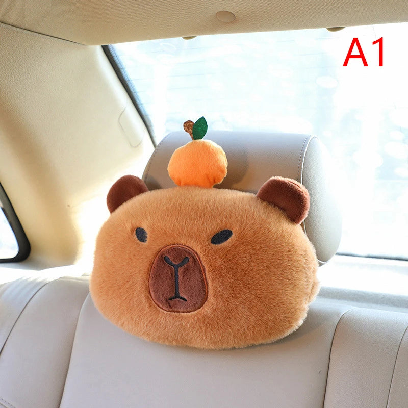 Capybara Car Headrest Neck Pillow & Tissue Holder – Plush Car Decor Plush bear headrest cover with a small orange on a car headrest