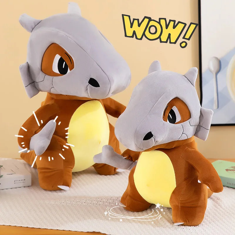Pokemon Cubone Plush Pillow – Soft Stuffed Animal Two small Charizard plush toys posed on a light surface against a beige indoor background, with one larger plush standing behind a smaller one and a yellow 'WOW!' text graphic in the upper right.