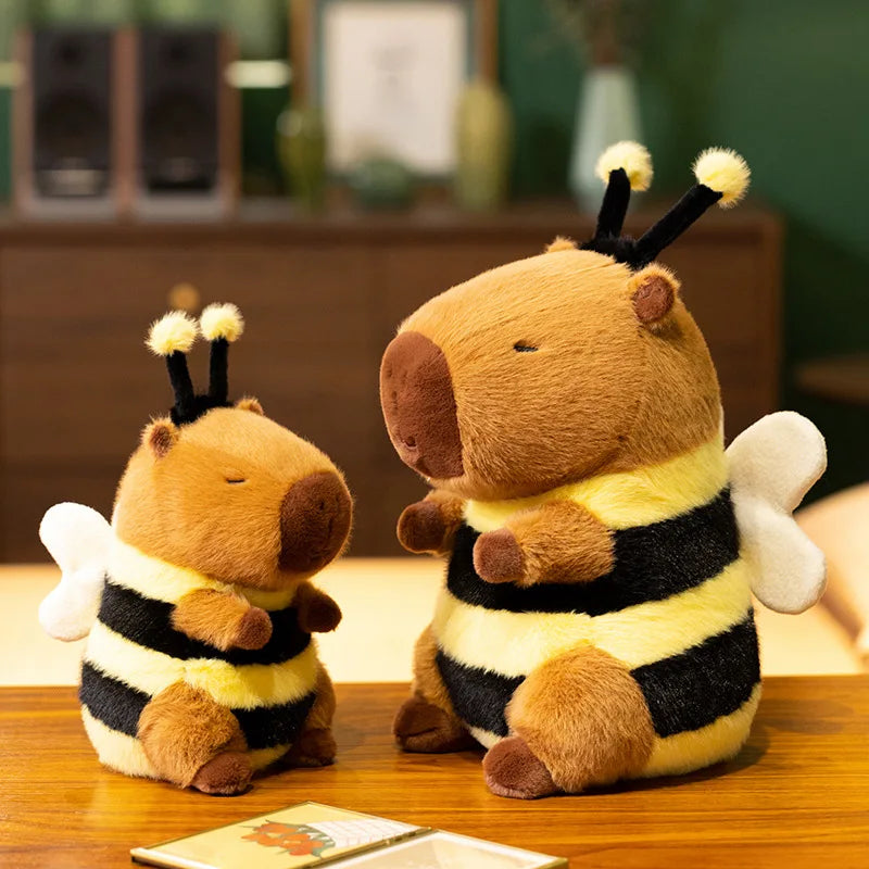 Bee Capybara Plush Toy – Kawaii Soft Stuffed Animal Two plush bee toys on a wooden surface with a blurred indoor background.