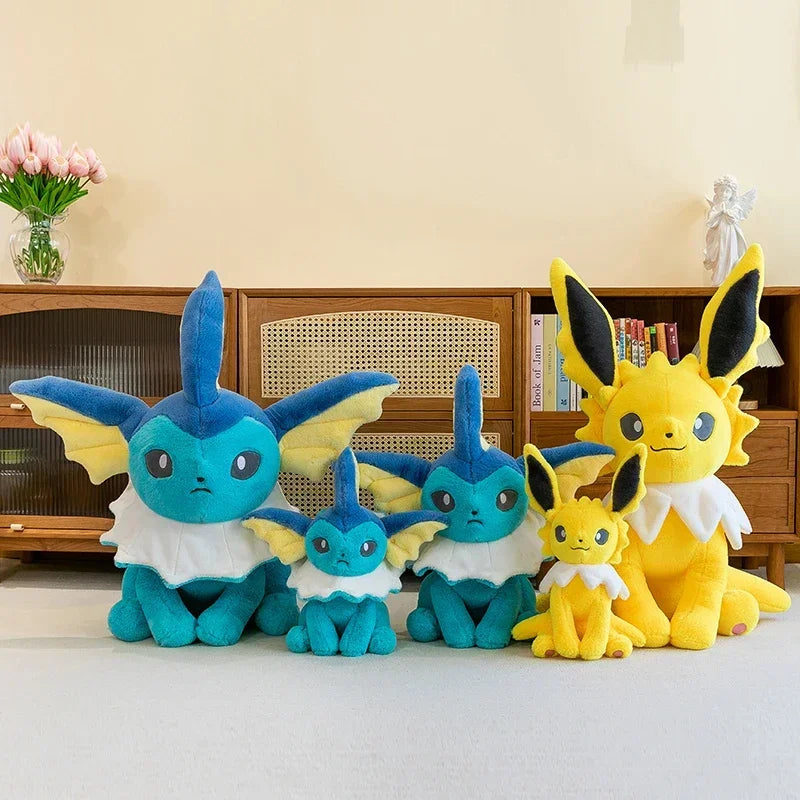 Pokemon Eevee Plush Toy – Vaporeon, Flareon & Jolteon Soft Stuffed Animal A set of five plush toy Eeveys in different sizes arranged in front of a wooden cabinet in a home interior setting.