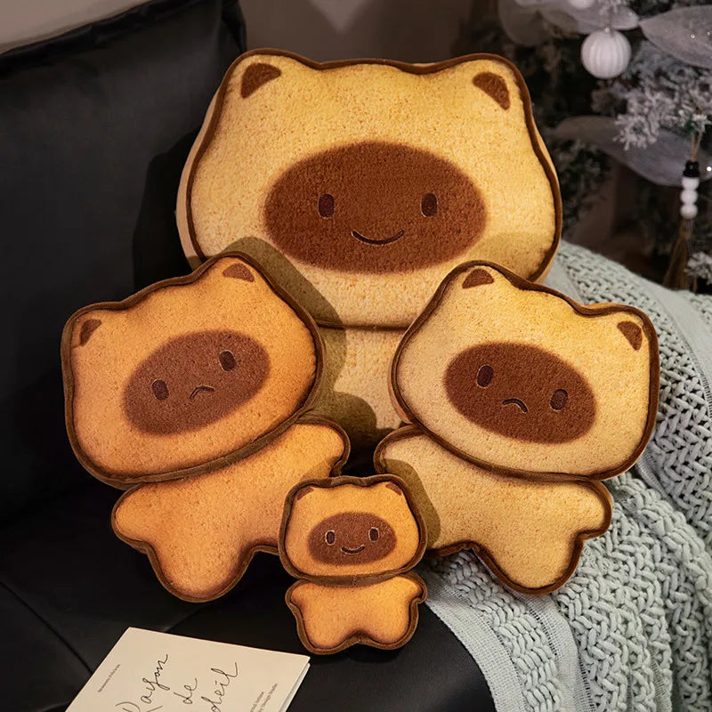 Capybara Bread Pillow – Cute Toast Plush Cushion Set of bear-shaped cushions with smiling faces on a dark surface.