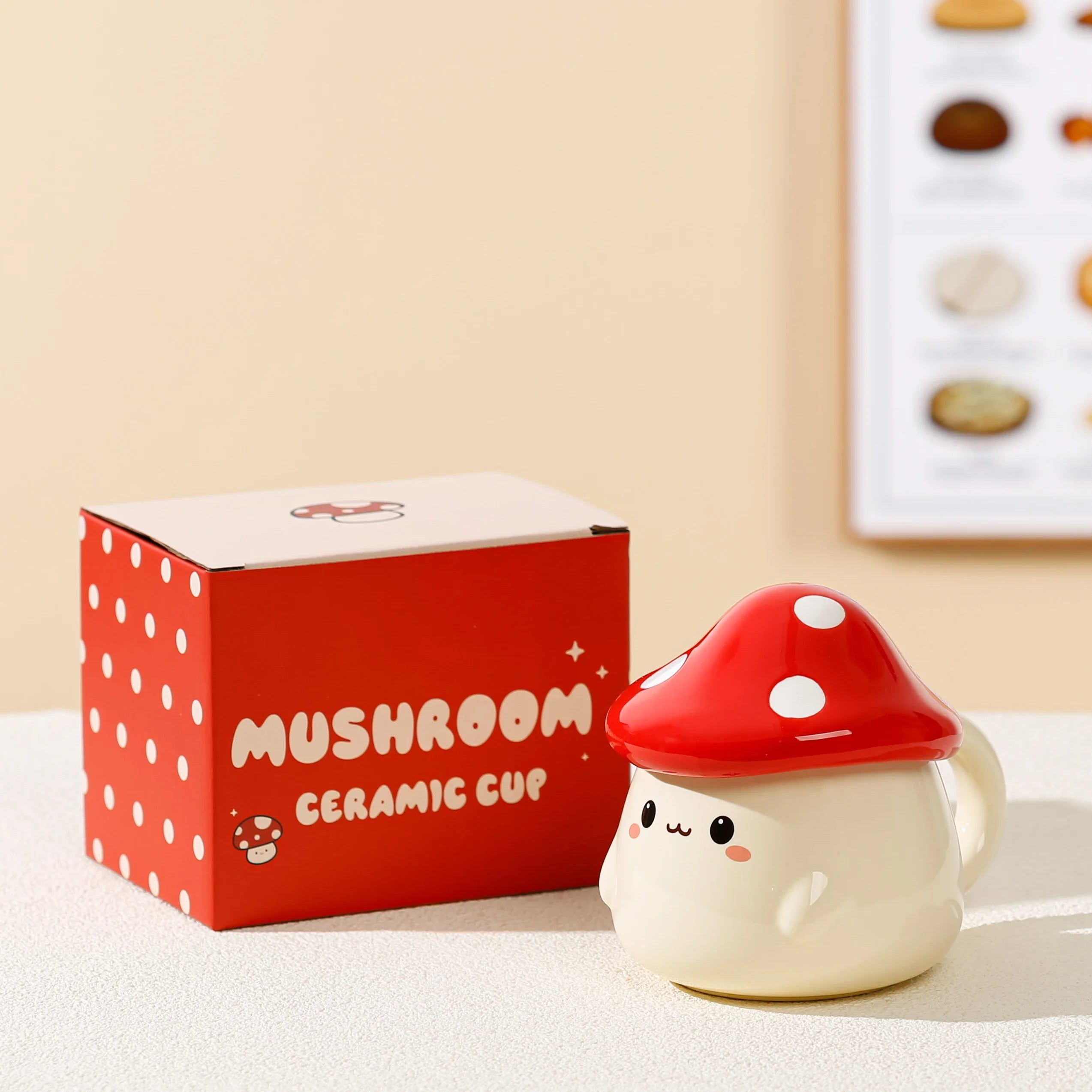 Cute Mushroom Coffee Mug with Lid – 400ML Ceramic Cup Mushroom-shaped ceramic cup with red lid next to a red box labeled 'Mushroom Ceramic Cup' on a beige surface.