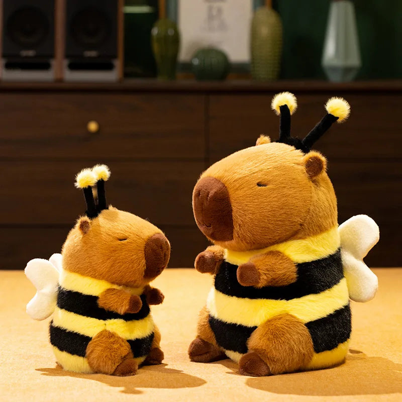 Bee Capybara Plush Toy – Kawaii Soft Stuffed Animal Two plush bee toys on a wooden surface with a blurred background