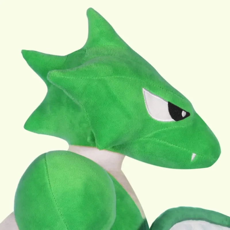 Pokemon Scyther Giant Plush Stuffed Toy A close-up of a green plush toy resembling a dragon or creature, shown against a plain light cream background.